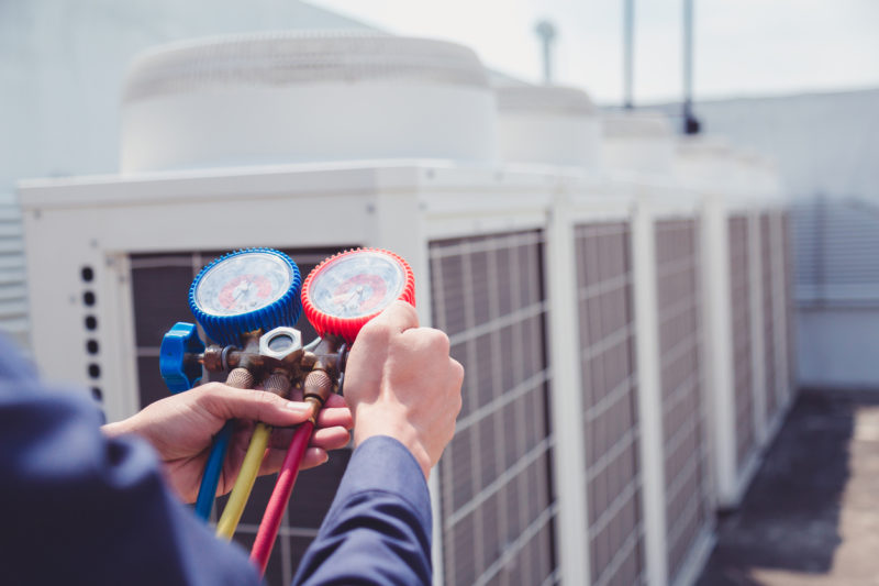 Technician is checking air conditioner ,measuring equipment for filling air conditioners.
